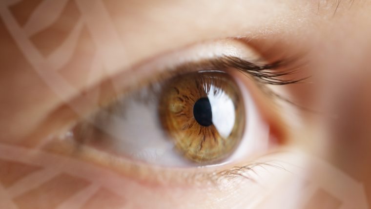 Photograph of a child’s eye with a floating DNA graphic layered over the image.