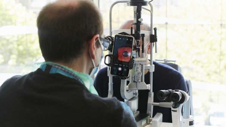 A clinician giving an eye test to a patient using a smartphone