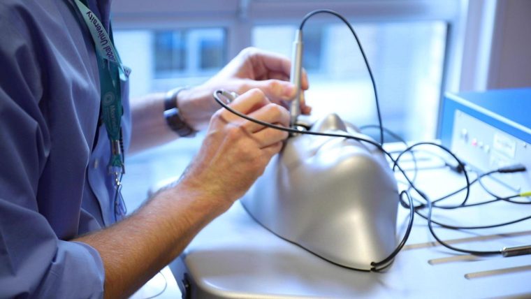 A man demonstrating how to use the surgical simulator.