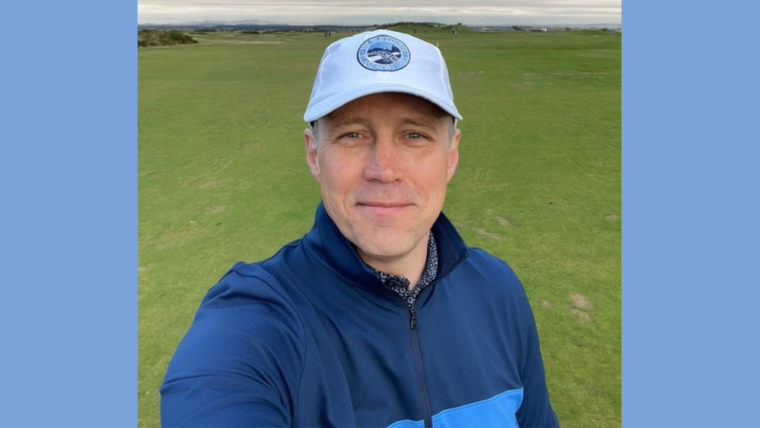 Robert Newcombe smiling. He is wearing a white cap.