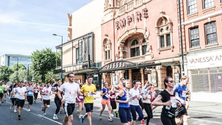 People running through Hackney in running vests under the sunshine