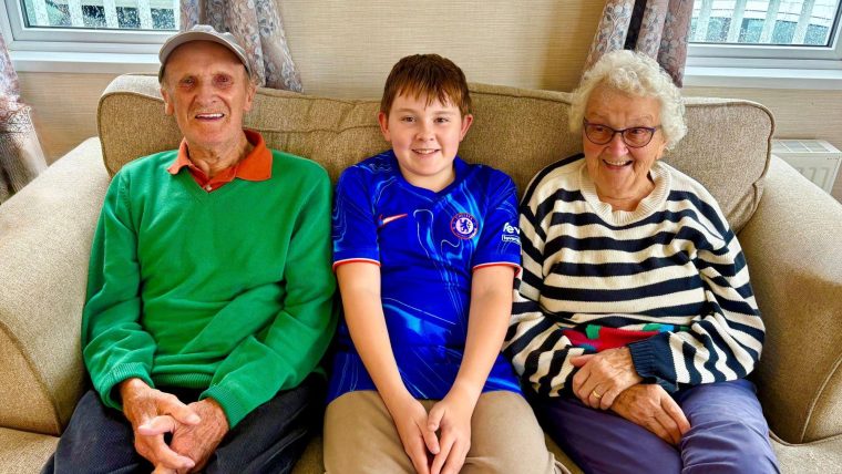 Three people sitting on a sofa.