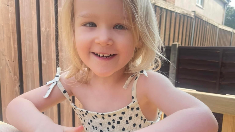 Photo of blonde child smiling at camera