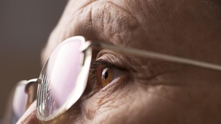 A close up of a bespectacled elderly person.