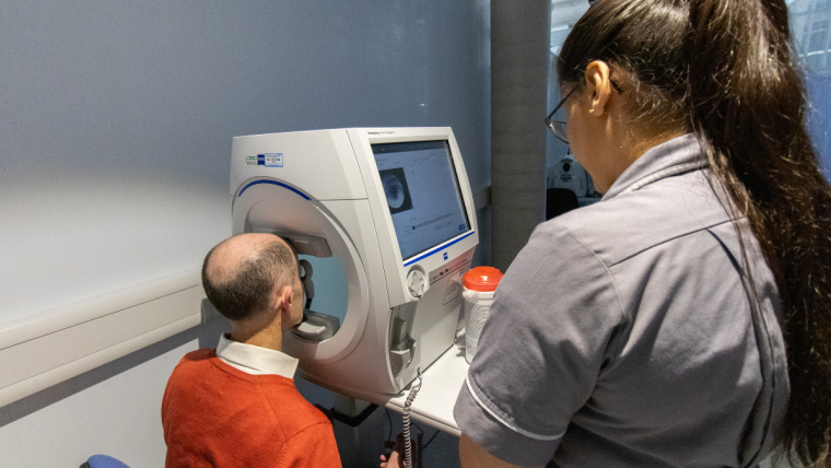 Moorfields Eye Charity CEO Robert Dufton undergoing an eye exam at Moorfields Hoxton with technician Alyzeh.