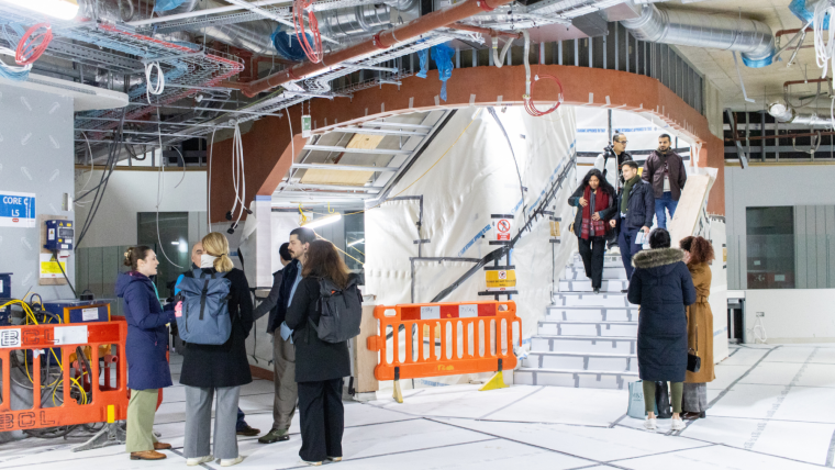 Two groups of staff and students exploring the atrium of the new centre.