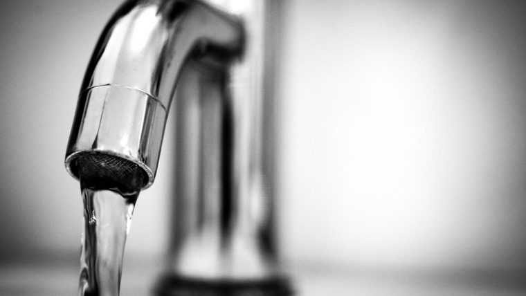 a close-up of a silver tap with running water coming out